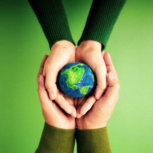 World Earth Day Concept. Green Energy, ESG, Renewable and Sustainable Resources. Environmental Care. Hands of People  Embracing a Handmade Globe. Protecting Planet Together. Top View